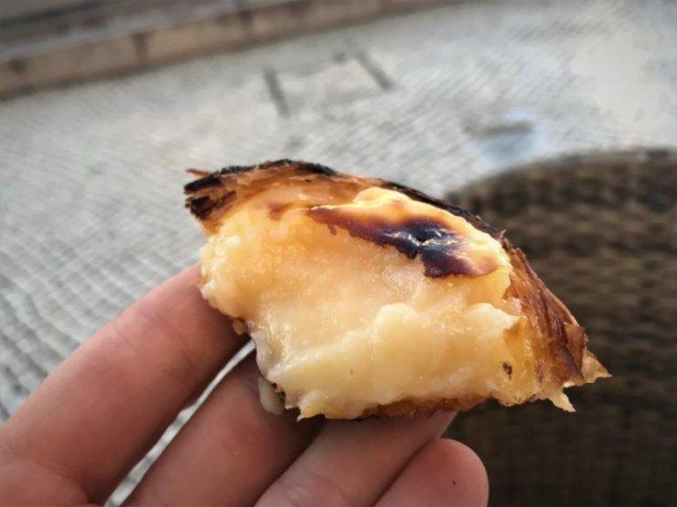 A bite off the crusty egg tart with soft custard inside. Hungry already! pastel de nata