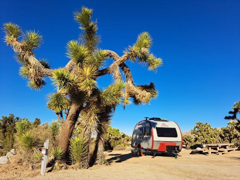 red and white rv camping trailer parked in the desert