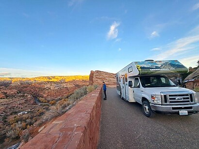 parked rv campervan cliff overlooking desert scenery