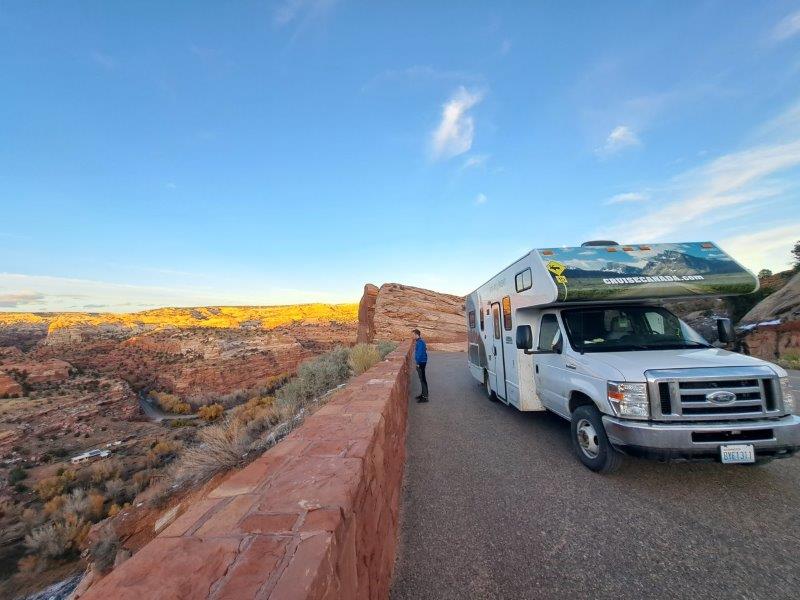 parked rv campervan cliff overlooking desert scenery