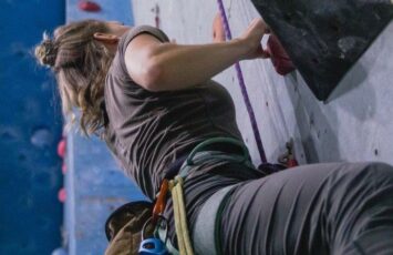 female rock climber with safety harness