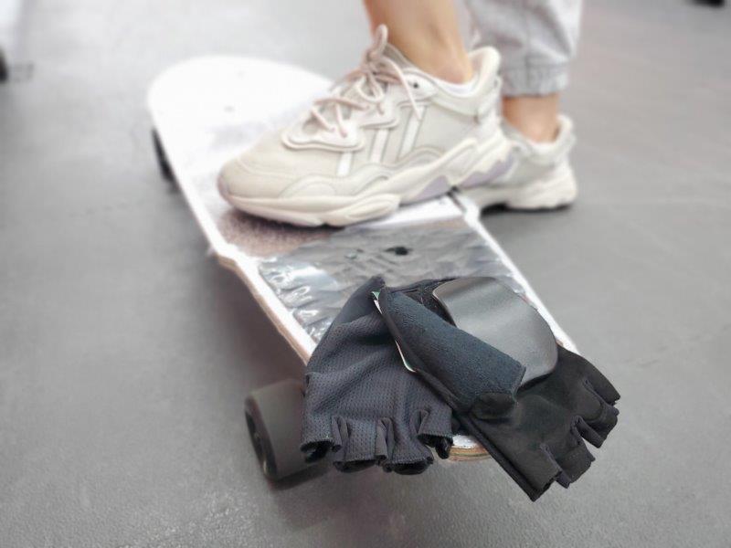 white shoe person on white skateboard black gloves