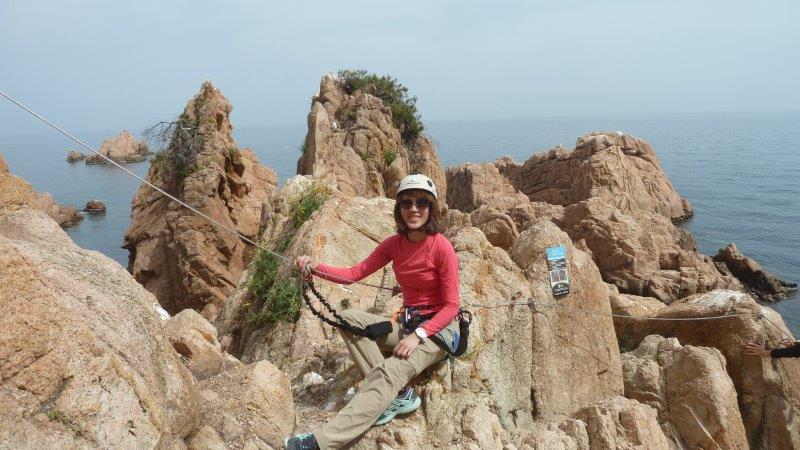 female climber posing while resting on cliff top