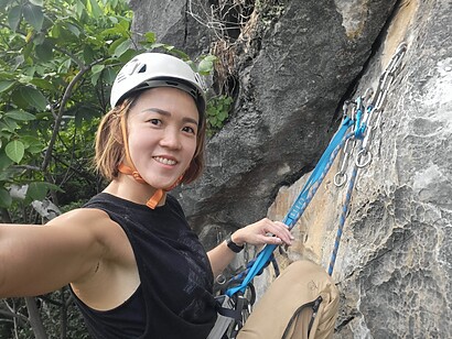 black shirt selfie while rock climbing in the forest with blue anchor sling selfie while rock climbing in the forest with blue anchor sling
